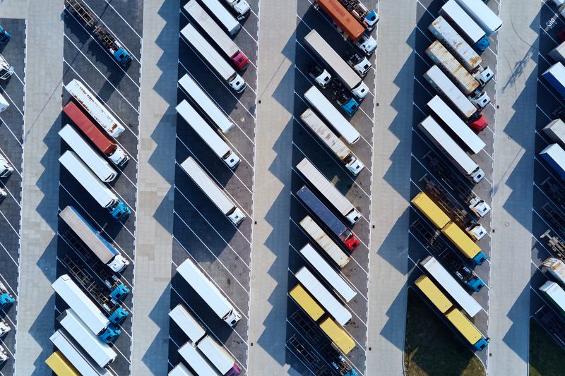 Rows of parked tractor-trailers seen from straight above